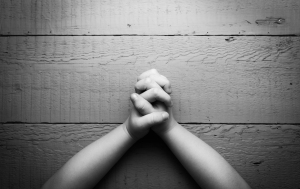 Child's hands folded together in prayer. Black and white photo